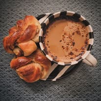 Kaffekopp och nybakade bullar sedda uppifrån